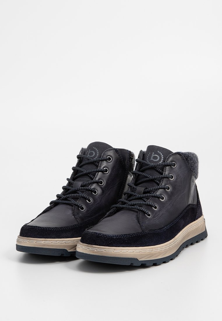 Hochschuh Stiefel aus navy Leder und Wildleder, mit strukturierten Akzenten, schwarzen Schnürsenkeln und einer beigen Gummisohle mit Profilrillen.