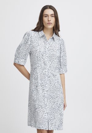 Button-up shirt dress featuring a white base with black and blue speckled print, short puff sleeves, and a straight fit.