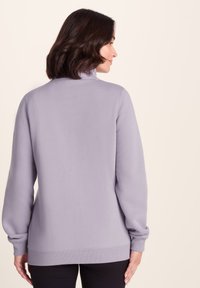 Light purple sweatshirt made of soft fabric, featuring a high collar, ribbed cuffs, and hem, with a relaxed fit. No visible patterns or accents.