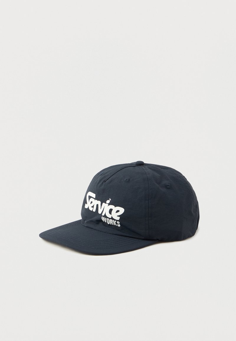Casquette bleu marine avec une visière incurvée, fabriquée en tissu léger. Présente le texte blanc "Service Works" à l'avant. Design simple et sportif.