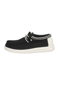 Scarpe slip-on nere in tela con suola bianca, pannello posteriore bianco a contrasto e strisce decorative. Fissate con un sistema di lacci strutturato.