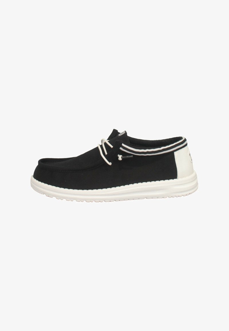 Scarpe slip-on nere in tela con suola bianca, pannello posteriore bianco a contrasto e strisce decorative. Fissate con un sistema di lacci strutturato.