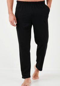 Pantalones negros con cintura elástica y corte recto. Tejido suave, con bolsillos laterales, diseñados para la comodidad y el uso diario.
