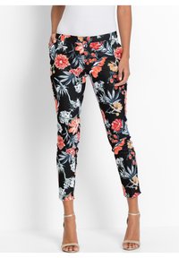 Pantalons à imprimé floral avec un fond noir, featuring des fleurs rouges et bleues, coupe slim, poches latérales et jambes fuselées. Tissu doux, design décontracté.