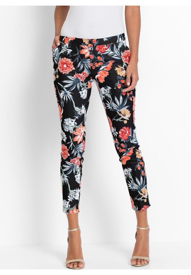 Pantalons à imprimé floral avec un fond noir, featuring des fleurs rouges et bleues, coupe slim, poches latérales et jambes fuselées. Tissu doux, design décontracté.
