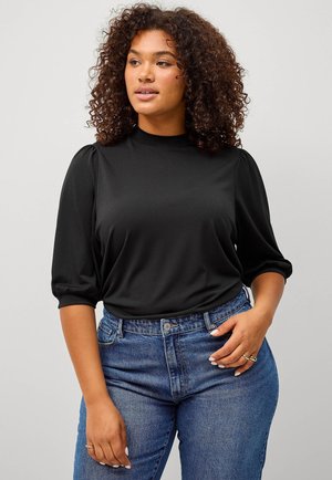 Zwarte, lichte top met een hoge hals en pofmouwen, gecombineerd met high-waisted blauwe jeans. Soepele textuur met een aansluitende silhouette.