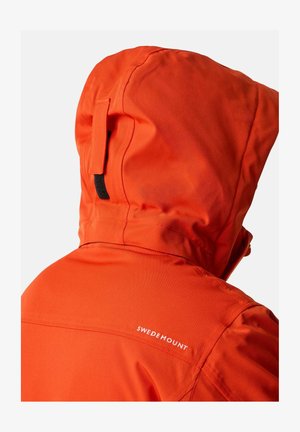 Orange wasserdichte Jacke mit einrollbarer Kapuze, verfügt über eine schwarze Schlaufe und einen weißen Logo-Text "SWEDEMOUNT" an der Schulternaht.