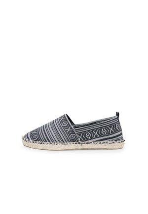 Espadrille de patrón en blanco y negro con un upper de tela texturizada y suela de yute trenzado. Presenta una punta redondeada y paneles laterales elásticos.