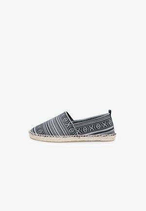Black and white patterned espadrille with a textured fabric upper and woven jute sole. Features a rounded toe and elastic side panels.