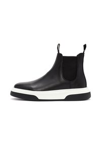 Botín Chelsea de cuero negro con paneles laterales elásticos, suela intermedia blanca y suela exterior negra en contraste. Incluye una lengüeta para facilitar su uso.