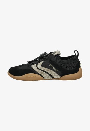Sneaker nera bassa con suola color cuoio, strisce di strass argento, collo della caviglia lavorato a maglia, lacci con chiusura a scatto e marchio "Steve Madden" sul lato e sulla suola.