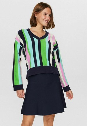Farverig stribet sweater med grønne, pink og blå nuancer, med en marineblå ribbet kant, parret med en marineblå yndlingsnederdel.
