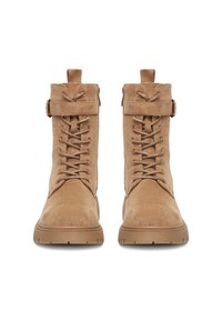 Béžové semišové boty s kulatou špičkou, šněrováním vpředu a páskem s kovovou přezkou kolem kotníku. Gumové podrážky pro lepší přilnavost a pohodlí.