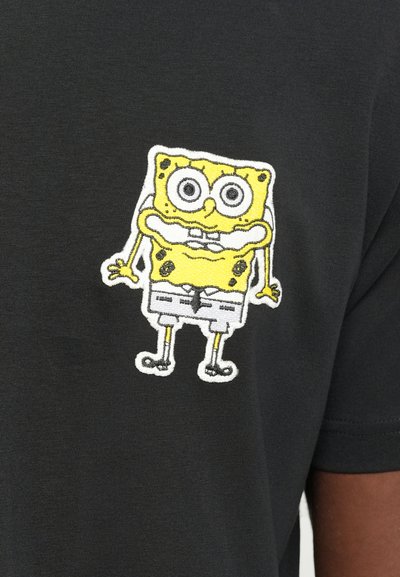 Black t-shirt featuring a yellow embroidered SpongeBob SquarePants design on the left chest area. The fabric is smooth and lightweight.