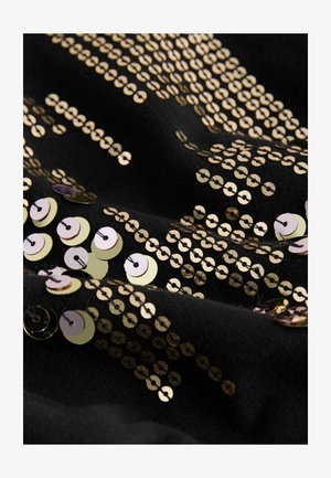 Tela negra con lentejuelas redondas doradas y metálicas dispersas de diferentes tamaños, creando un patrón de superficie texturizada y reflectante.