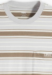 Camiseta de rayas en gris claro con rayas horizontales en marrón y blanco. Presenta un escote redondo y un pequeño logotipo bordado en el pecho.