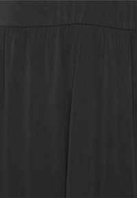 Tecido leve e preto com uma textura suave, apresentando uma cintura franzida. O design é simples e fluido.