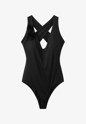 Czarny jednoczęściowy kostium kąpielowy z krzyżującymi się paseczkami na plecach i dwoma tkaninowymi kwiatowymi zdobieniami na lewym ramieniu.