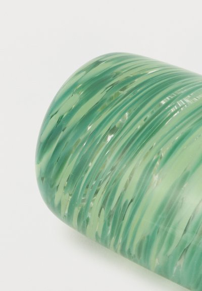 Πράσινο γυάλινο βάζο με ανάγλυφες σπειροειδείς αυλακώσεις, στρογγυλό σχήμα και λείο γυαλιστερό επιφάνεια σε απλό λευκό φόντο.