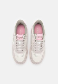 Lacoste'i tossud valge nahkse ülemise osaga, hallide aktsentidega, roosa keelega ja sisetallaga. Omab perforatsioone varvaste piirkonnas ventilatsiooni tagamiseks.