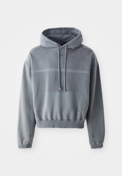 Sudadera gris hecha de material tipo sudadera; cuenta con capucha ajustable, puños de canalé y un bolsillo tipo canguro en la parte frontal con un diseño difuminado.