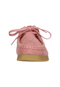 Scarpa mocassino in camoscio rosa con lacci legati e suola in crepe beige, vista frontale su uno sfondo bianco.