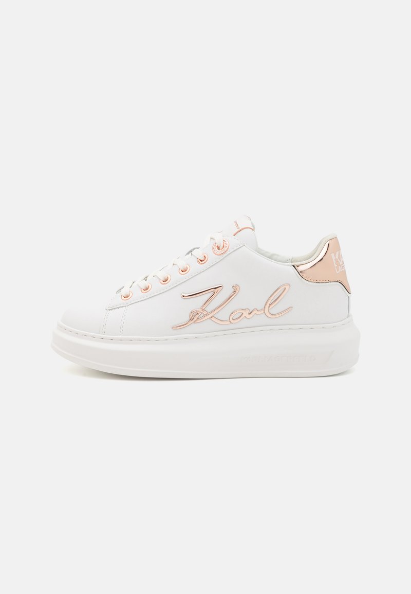 Baskets blanches avec une finition en cuir lisse, présentant des accents en or rose, un logo sur le côté et un design de semelle épaisse blanche.