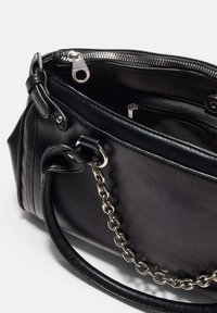 Sac à main en cuir noir avec accent chaîne, fermeture éclair et texture lisse. Doté de poignées doubles et d'un intérieur spacieux avec des poches.