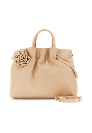 Béžová kožená kabelka s oblými rukojetmi, květinovou ozdobou vlevo a odnímatelným ramenním popruhem umístěným vpředu.