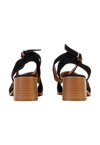 Paire de sandales en daim noir avec brides à la cheville et talons moyens en bois empilés, vues de dos sur fond blanc