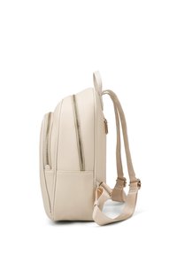 Zaino in ecopelle beige con due scomparti con zip, spallacci regolabili e accessori in tonalità oro. Texture liscia e design strutturato.