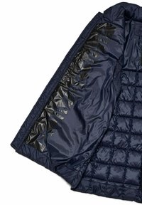 Giacca imbottita blu navy con un interno nero lucido caratterizzato da un motivo trapuntato e un logo stampato in nero sul lato. Texture liscia.