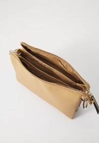 Tan leather bag with two compartments, a gold zipper, and a keyring attached. Smooth texture with a structured, rectangular shape.