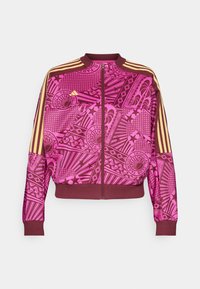 Roze bomberjack met geometrische patronen, gouden accenten op de mouwen, hoge kraag en ritssluiting aan de voorkant. Gemaakt van gladde stof.