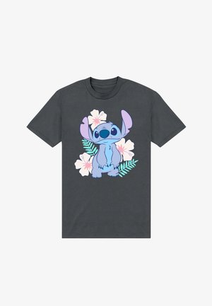 T-shirt gris foncé présentant au centre un personnage de dessin animé bleu avec de grandes oreilles, entouré de fleurs d'hibiscus roses et blanches ainsi que de feuilles vertes.