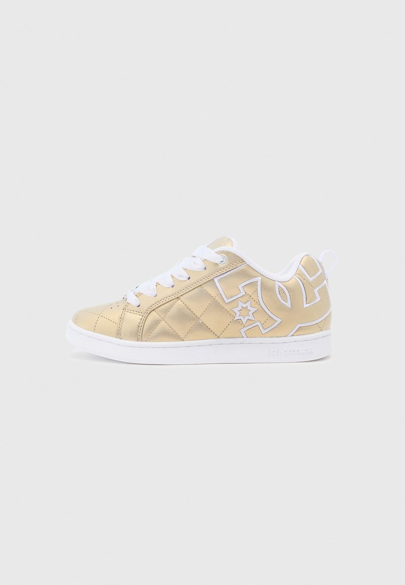 Beige kvartrētie čības ar baltām mežģīnēm un zoli. Izceļas ar izteiktu baltu logotipu un zvaigžņu dizainu sānos. Gluda tekstūra.