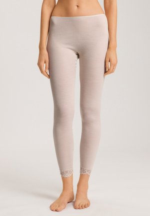 Light beige ribbed leggings with a fitted design, featuring lace accents at the hem. Made of soft fabric, they have a smooth texture.