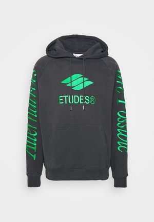 Tummanharmaa hupullinen collegepaita, jossa vihreä "ETUDES®"-logo rinnassa ja vihreää käsinkirjoitettua tekstiä kummassakin hihassa.