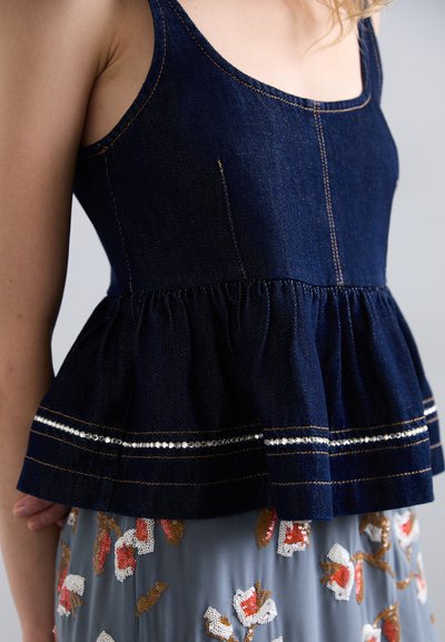 Denim-Peplum-Top in dunkelblauer Farbe mit dünnen Trägern und goldenen Nähten; zeichnet sich durch einen gerafften Saum und Strassakzentstreifen aus.