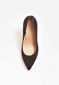 Chaussure plate pointue en suède noir avec un design à côté ouvert et une semelle intérieure en cuir lisse. Présente un accent métallique sur le talon.