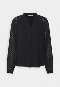 Blouse noire à manches longues avec manches semi-transparentes à motif zigzag et fermeture boutonnée devant.