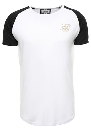 Camiseta blanca con mangas raglán cortas negras y pequeño logo de la marca bordado en dorado en el pecho izquierdo.