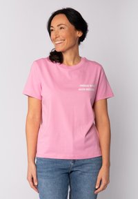 Korte mouwen roze katoenen t-shirt met ronde hals, voorzien van witte tekst "FRÜHER WAR ALLES BESSER" op de voorkant. Zachte textuur, casual pasvorm.