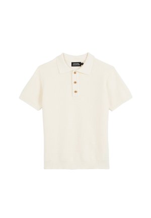 Polo en maille crème à manches courtes avec trois boutons en bois et un ourlet côtelé, posé à plat sur un fond blanc.