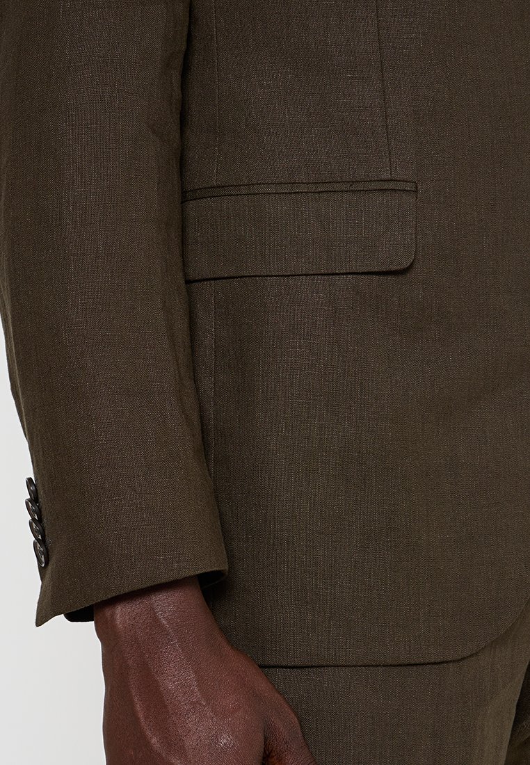Brauner Leinenblazer mit Reverskragen, einer vorderen Tasche und vier-Knopf-Manschette. Strukturiertem Stoff mit dezentem Glanz.