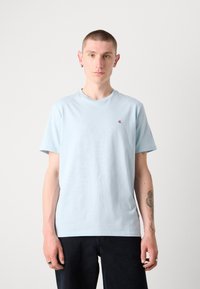 Tricou din bumbac de culoare albastru deschis, cu guler rotund și mâneci scurte. Are un mic logo brodat în roșu închis pe piept.