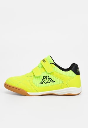 Jasnożółty sneaker Kappa z dwoma paskami na rzep, czarne logo z boku, czarny kołnierz i podeszwa w kolorze gumy.