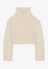 Pull col roulé en crochet couleur crème, avec une coupe courte, un corps en maille texturée et un motif en chevrons sur les manches.