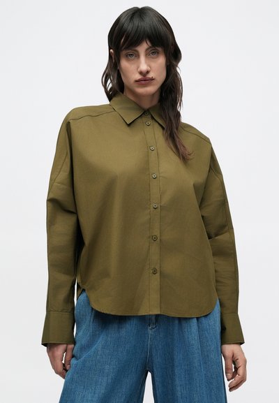 Πουκάμισο σε ελιά πράσινο με κουμπιά μπροστά, γιακά, άνετη εφαρμογή και καμπυλωτό τελείωμα. Διαθέτει μπροστινά κουμπιά και διακριτικές λεπτομέρειες ραφής.