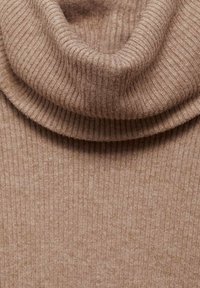Pull en cachemire beige à col roulé avec une texture douce, présentant un col replié et un motif de tricot vertical.